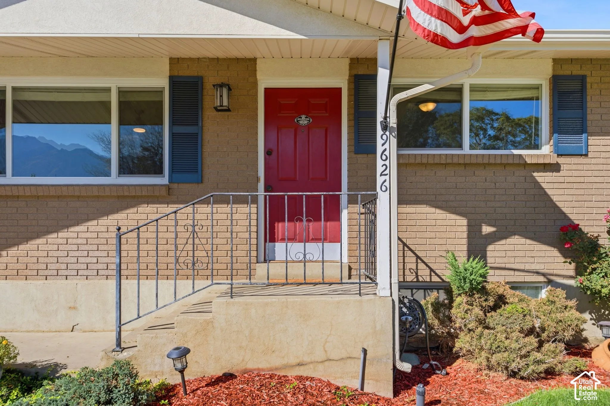 Brick exterior with a red entry door