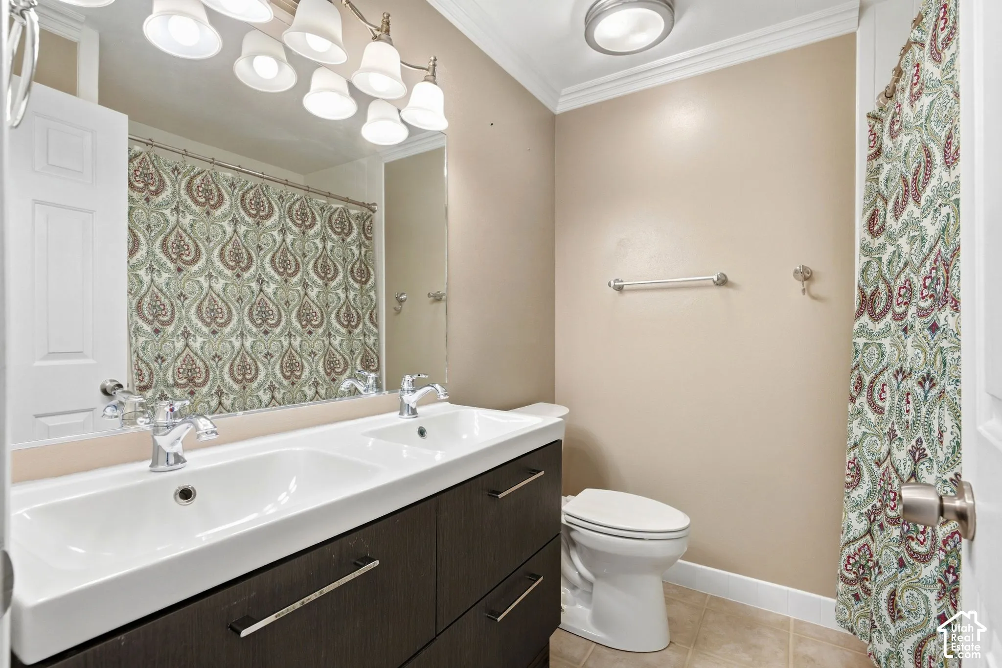 Dual vanity with integrated sinks, chrome faucets, and dark wood-finish cabinetry