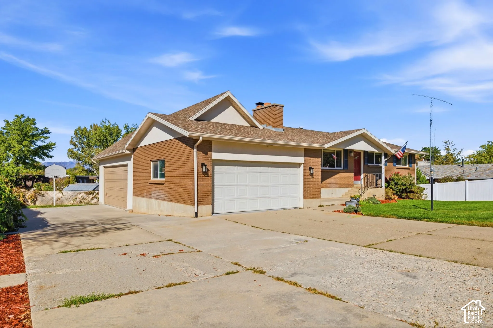 Brick exterior with white trim, a multi-car driveway, and an attached two-car garage