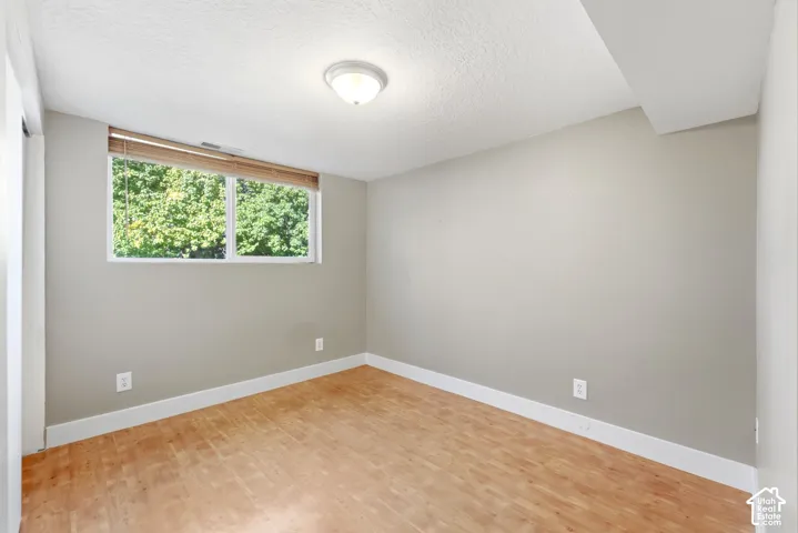 Recessed window with natural light, wood-finish flooring, white baseboards, and light gray wall paint