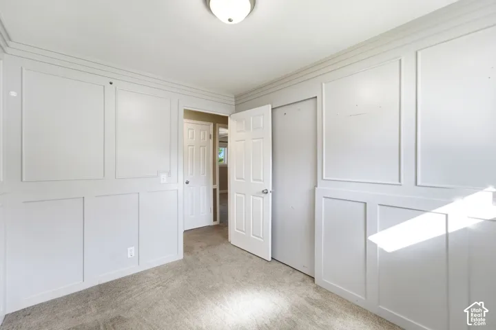Panel-style wall trim, neutral-tone carpeting, flush mount ceiling light, and interior paneled doors