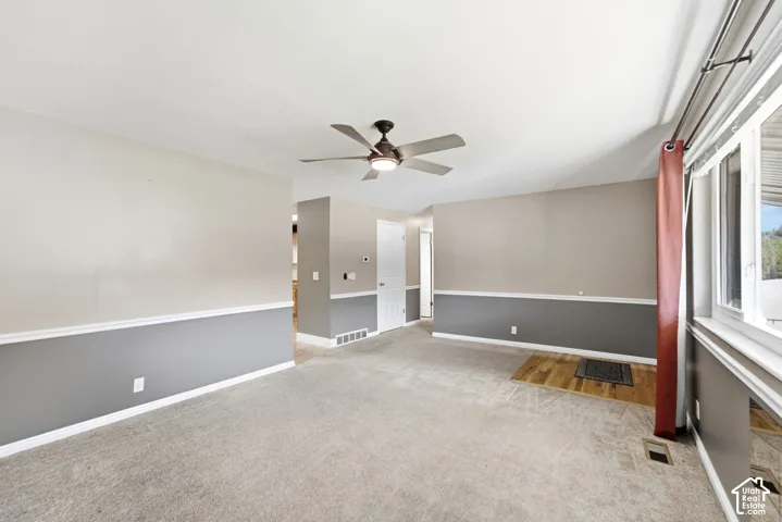 Recessed lighting, ceiling fan with integrated lighting, wood-finish flooring, two-tone wall treatment, and large windows