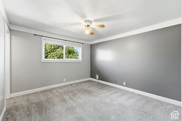 Recessed lighting, ceiling fan, carpeted flooring, window with white trim, and crown molding
