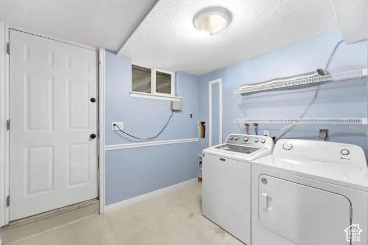 Utility area featuring a top-load washing machine, front-load dryer, and wall-mounted shelving