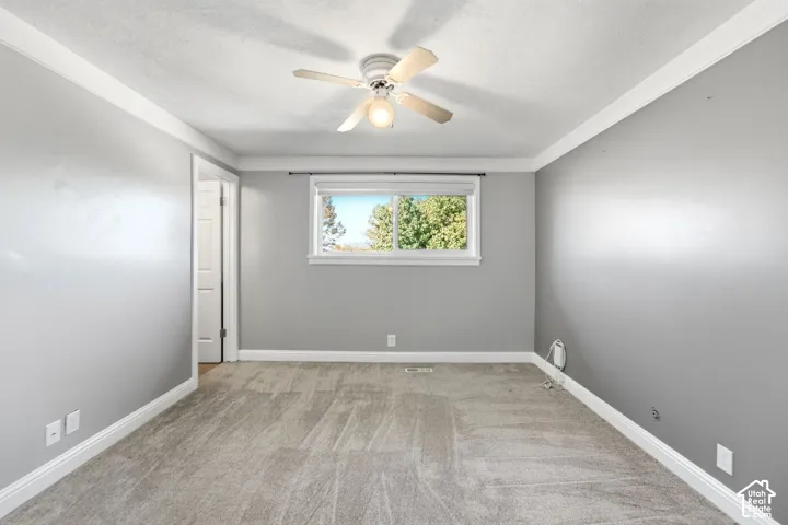 Spacious bedroom with neutral gray walls, wood-finish flooring, and recessed lighting throughout