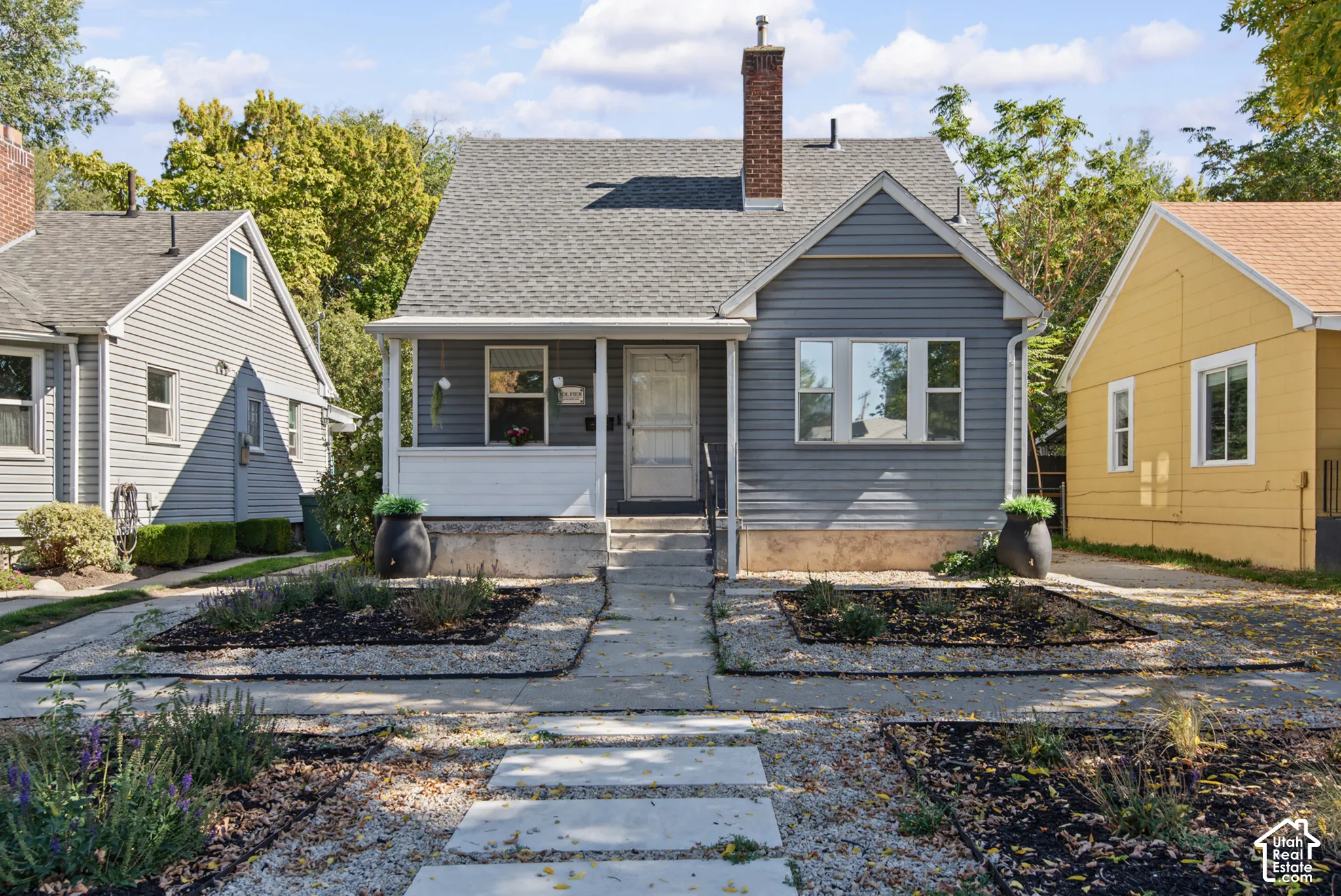 Gray horizontal siding with white trim, gray shingle roof, and a red brick chimney