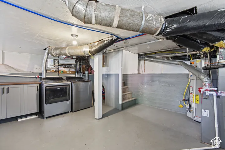 Utility area with a built-in countertop, base cabinetry, and a concrete floor