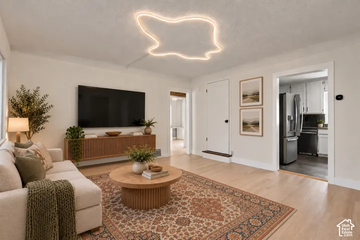 Light wood-finish flooring, white walls, and a built-in media console with slatted wood details