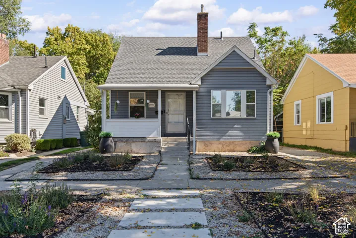 Gray horizontal siding with white trim, gray shingle roof, and a red brick chimney