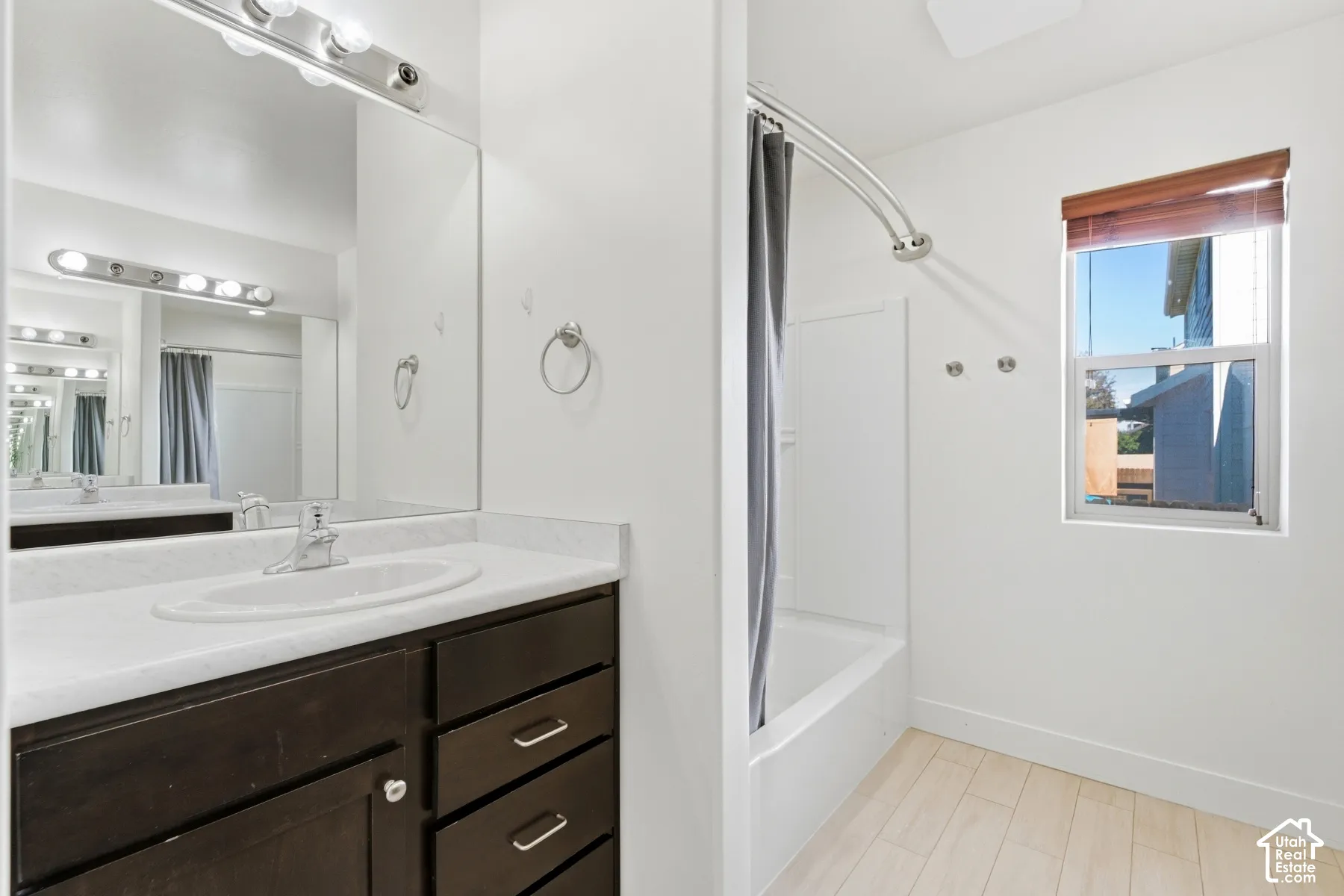 Vanity with dark wood cabinetry, integrated sink, and overhead lighting