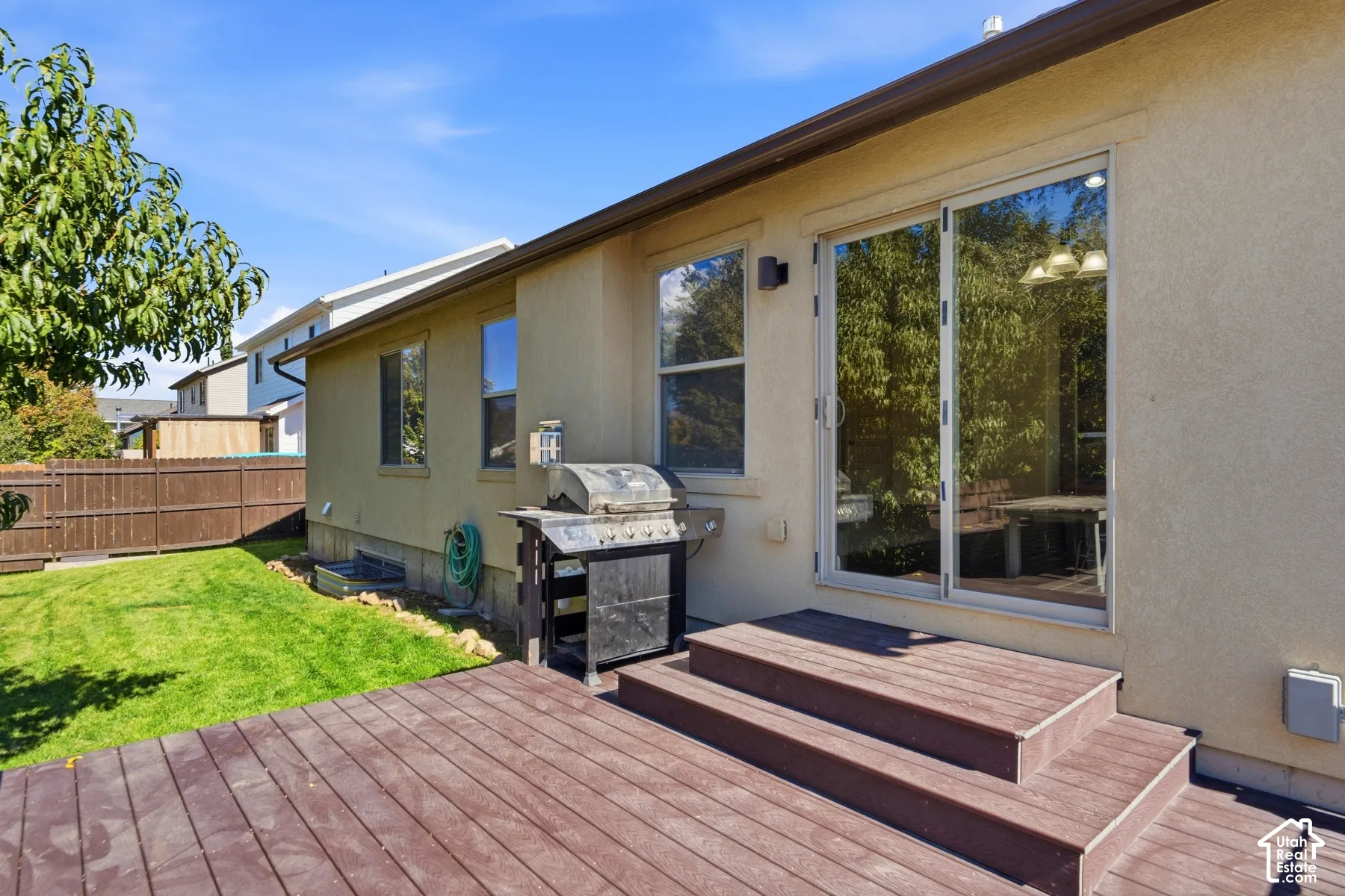 Expansive rear deck with multi-level steps and sliding glass door access