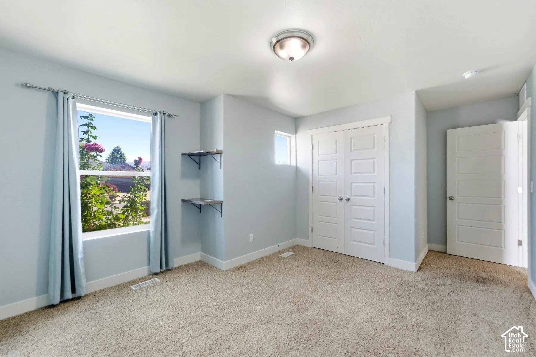Wall-to-wall carpeting, dual windows, built-in shelving, and white paneled doors