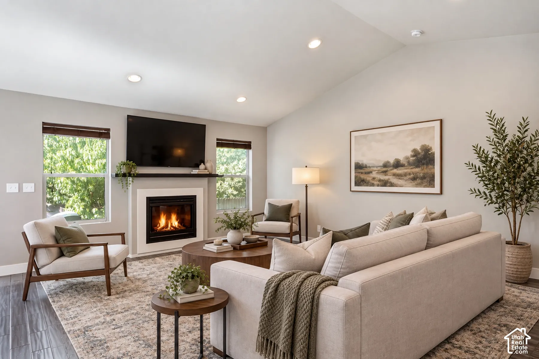 Vaulted ceiling, recessed lighting, and a fireplace with a white mantel and dark wood shelf
