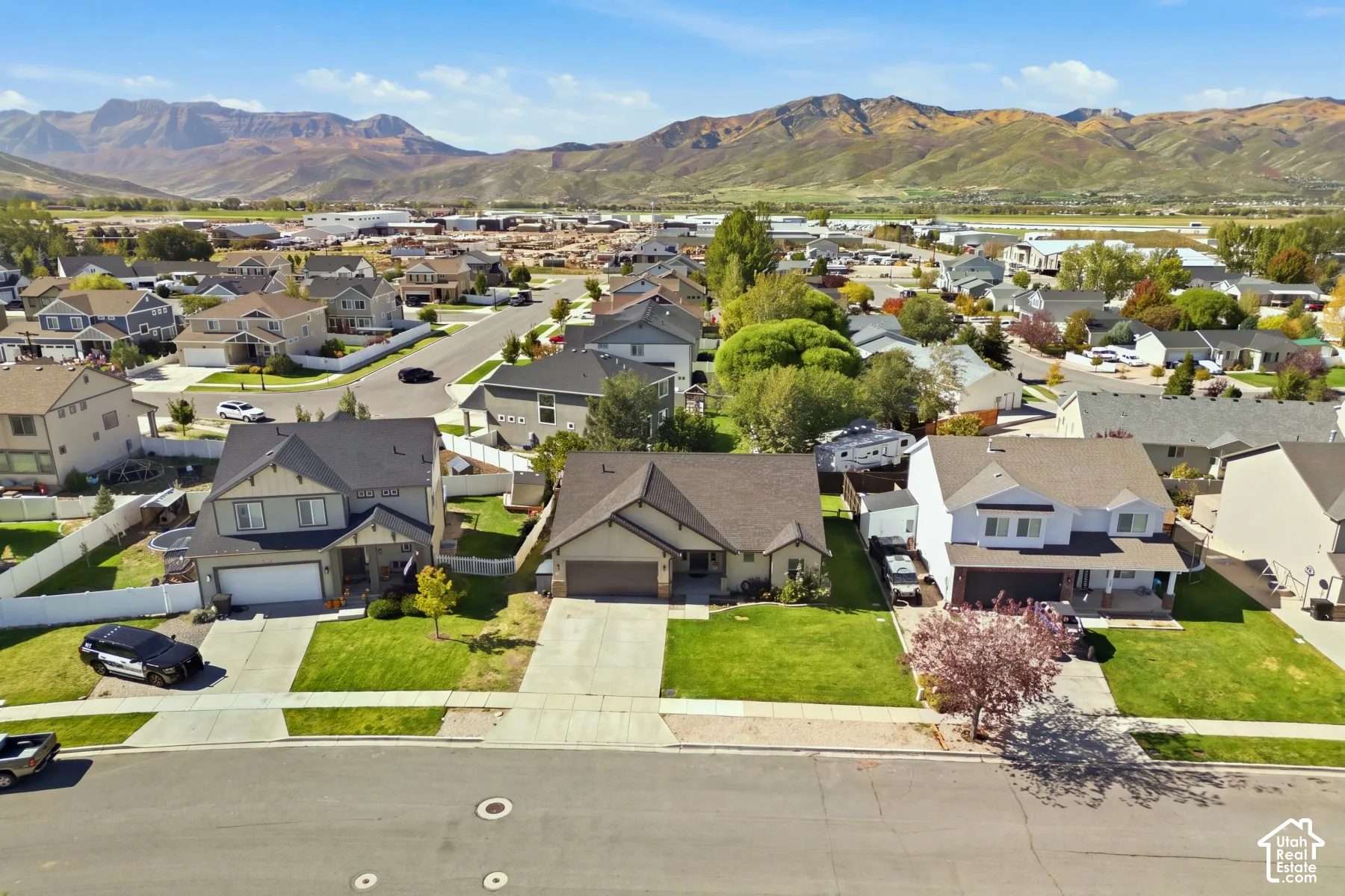 Residential neighborhood with varied house styles and mature landscaping, framed by distant mountains