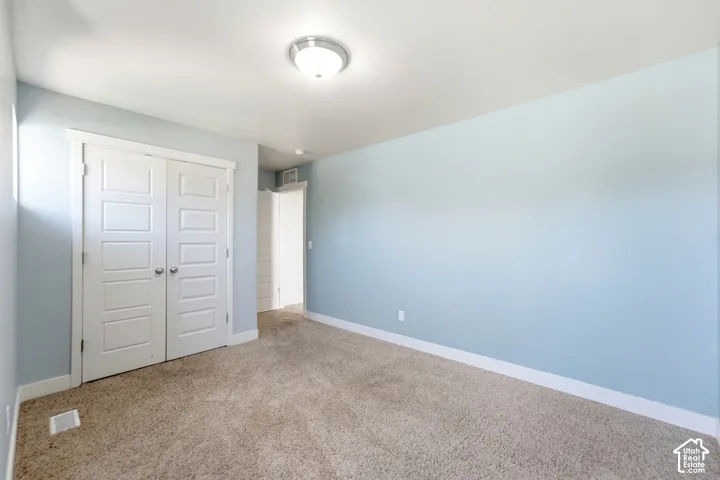 Light blue painted walls, carpeted flooring, and white trim