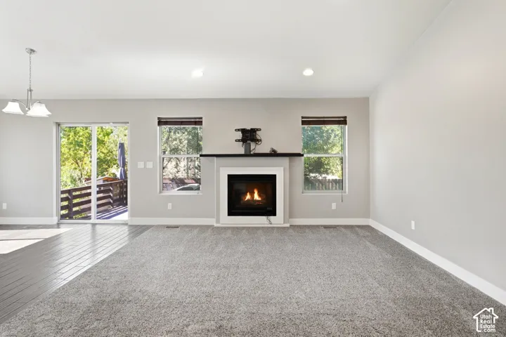 Fireplace with a dark mantle, large sliding glass door, recessed lighting, and mixed flooring