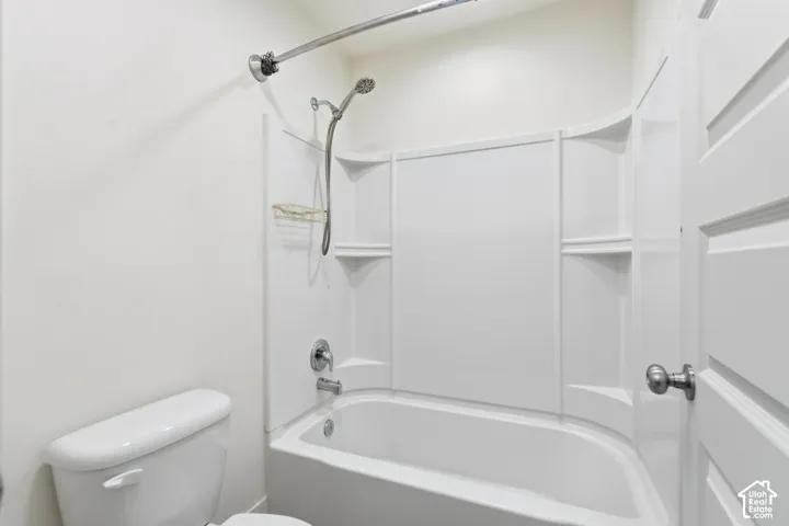 White tub and shower combination with a curved shower rod and brushed nickel fixtures