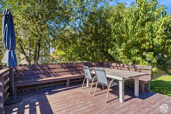 Wood-finish deck featuring built-in bench seating and a level lawn area