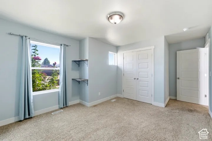 Wall-to-wall carpeting, dual windows, built-in shelving, and white paneled doors