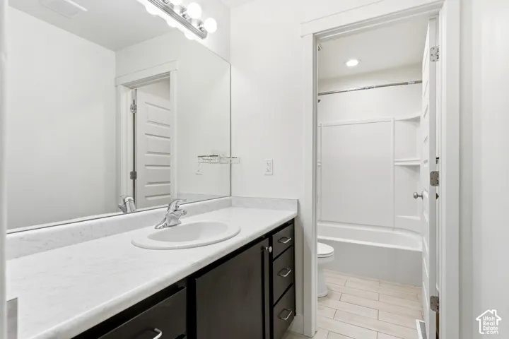 Vanity featuring an integrated sink, polished chrome faucet, and dark wood-finish cabinetry