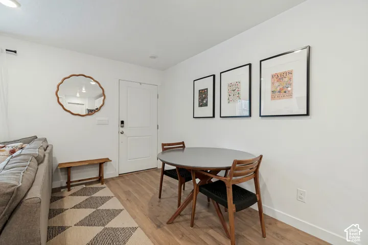 Wood-finish flooring with white wall finishes, recessed lighting, and a solid panel interior door