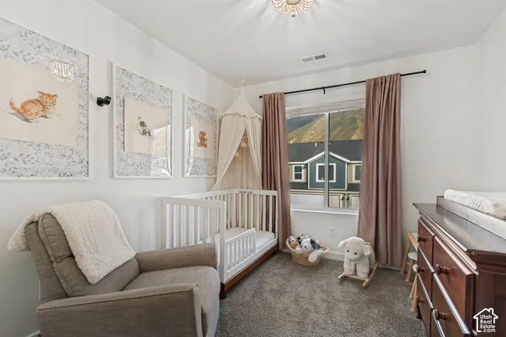 Carpeted room with a large window, crown molding, and a chandelier-style ceiling fixture