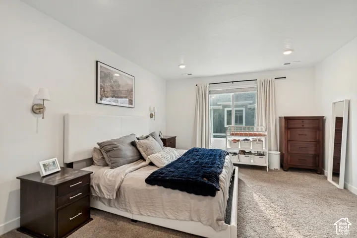 Recessed lighting, wall-mounted sconces, light-colored walls, and carpet flooring