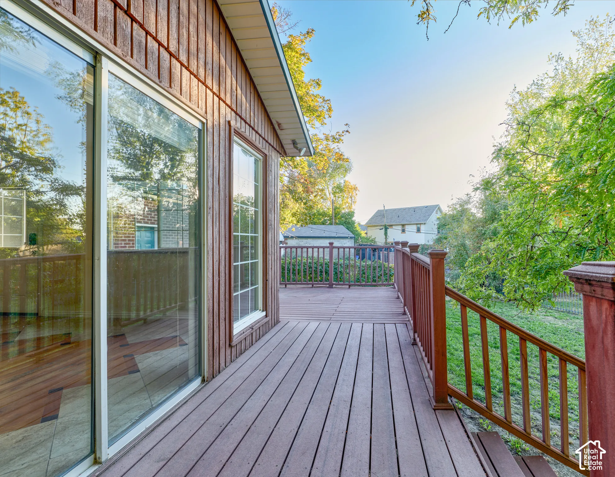 Expansive outdoor deck with composite decking and wood railings, complemented by vertical wood siding