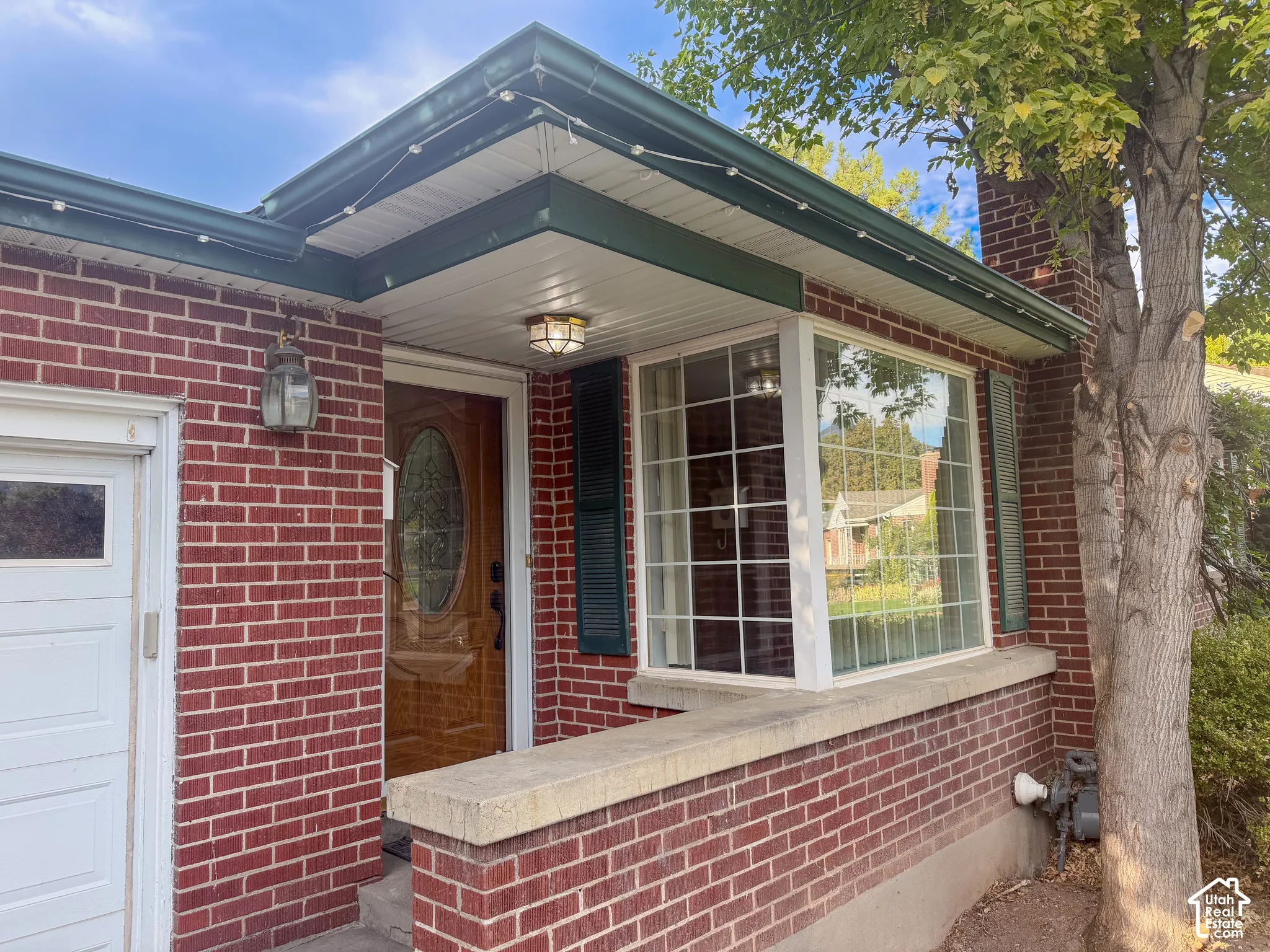 Brick exterior with a bay window and dark green shutters