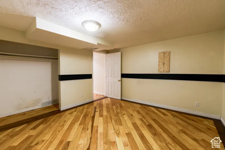 Wood-finish flooring, overhead flush mount light fixture, interior door, and built-in closet space