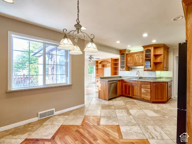 Kitchen featuring wood cabinetry, stainless steel dishwasher, granite countertops, and recessed lighting