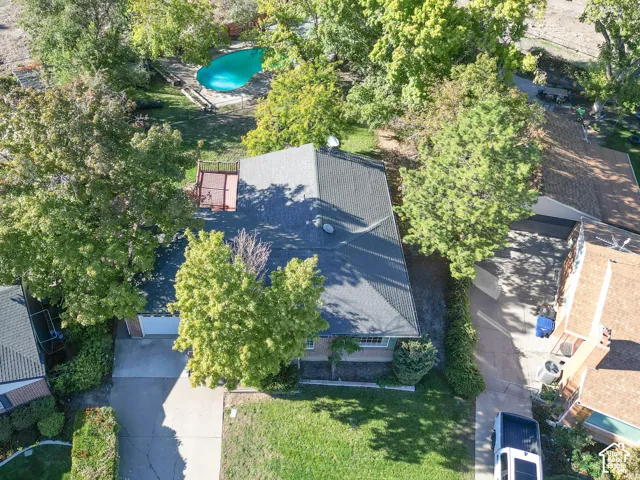 Expansive property featuring a swimming pool, mature trees, a wraparound deck, and an attached garage