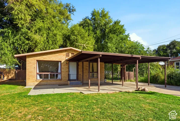 Brick exterior with a large front window and a covered carport