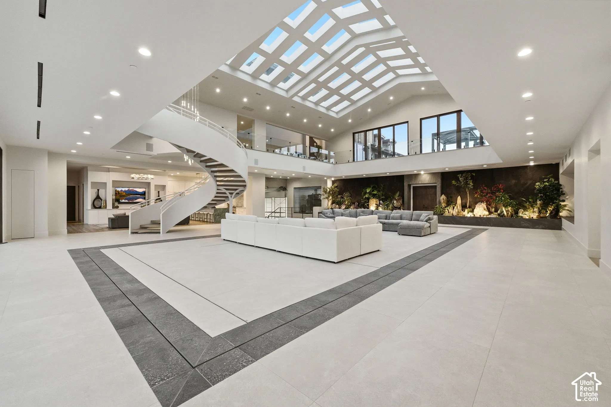 Expansive open-concept interior with a dramatic skylight ceiling and recessed lighting