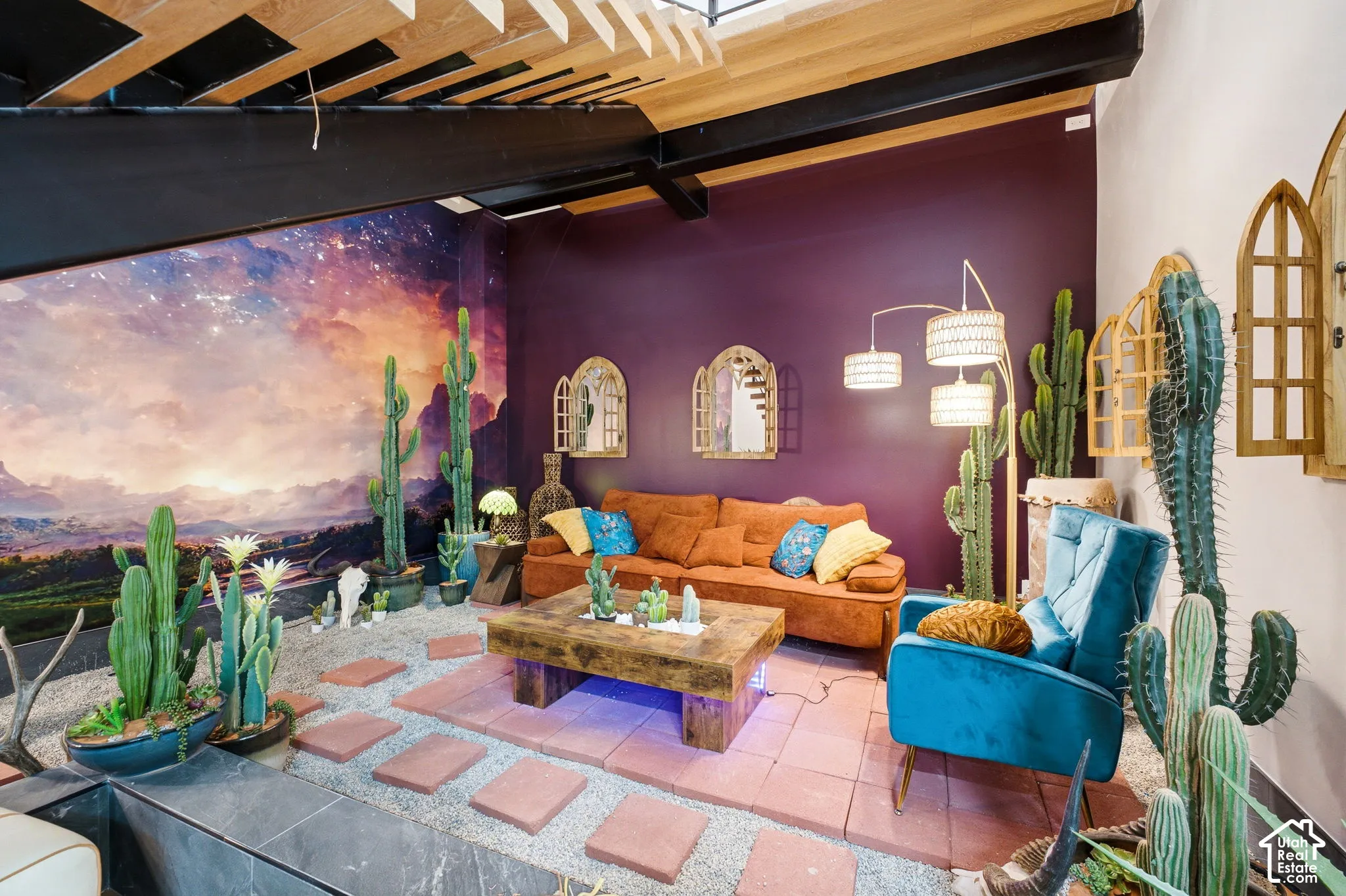 Exposed ceiling beams, vibrant accent wall, stone-finish flooring, and decorative wall mirrors