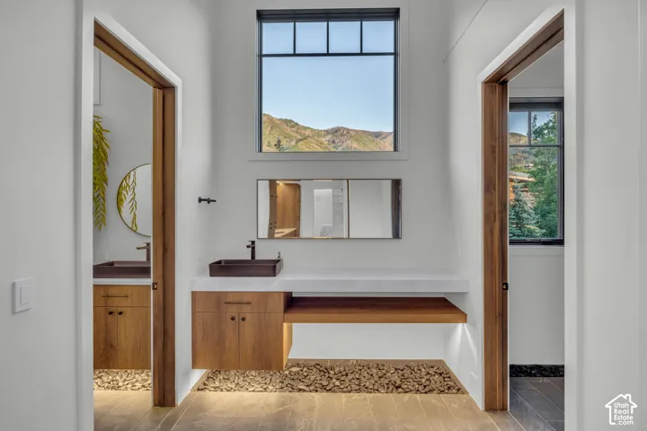 Modern floating vanity with a rectangular vessel sink, wood-finish cabinetry, and under-cabinet lighting