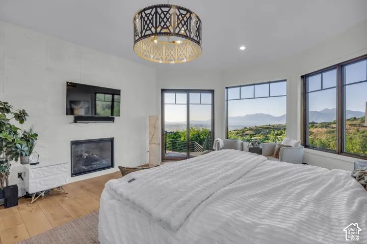 Built-in fireplace with a dark metal frame, wood-finish flooring, and a decorative ceiling light fixture