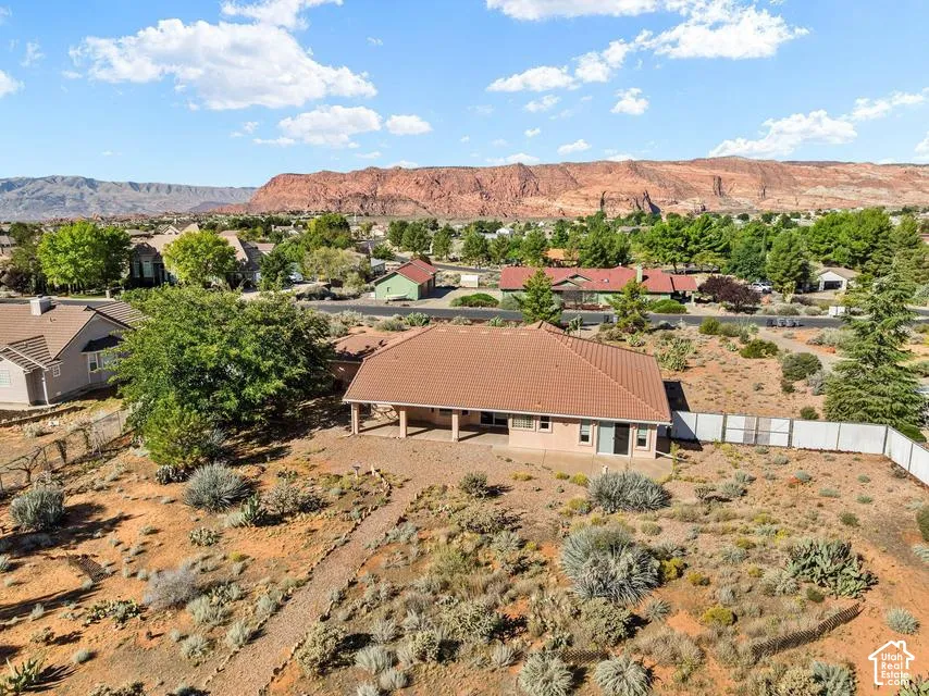 South-facing property with a covered patio and a distinct terracotta-colored tile roof