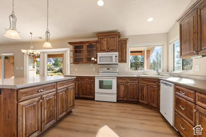 Kitchen featuring wood-finish flooring, recessed lighting, wood cabinetry, and a center island with pendant lighting