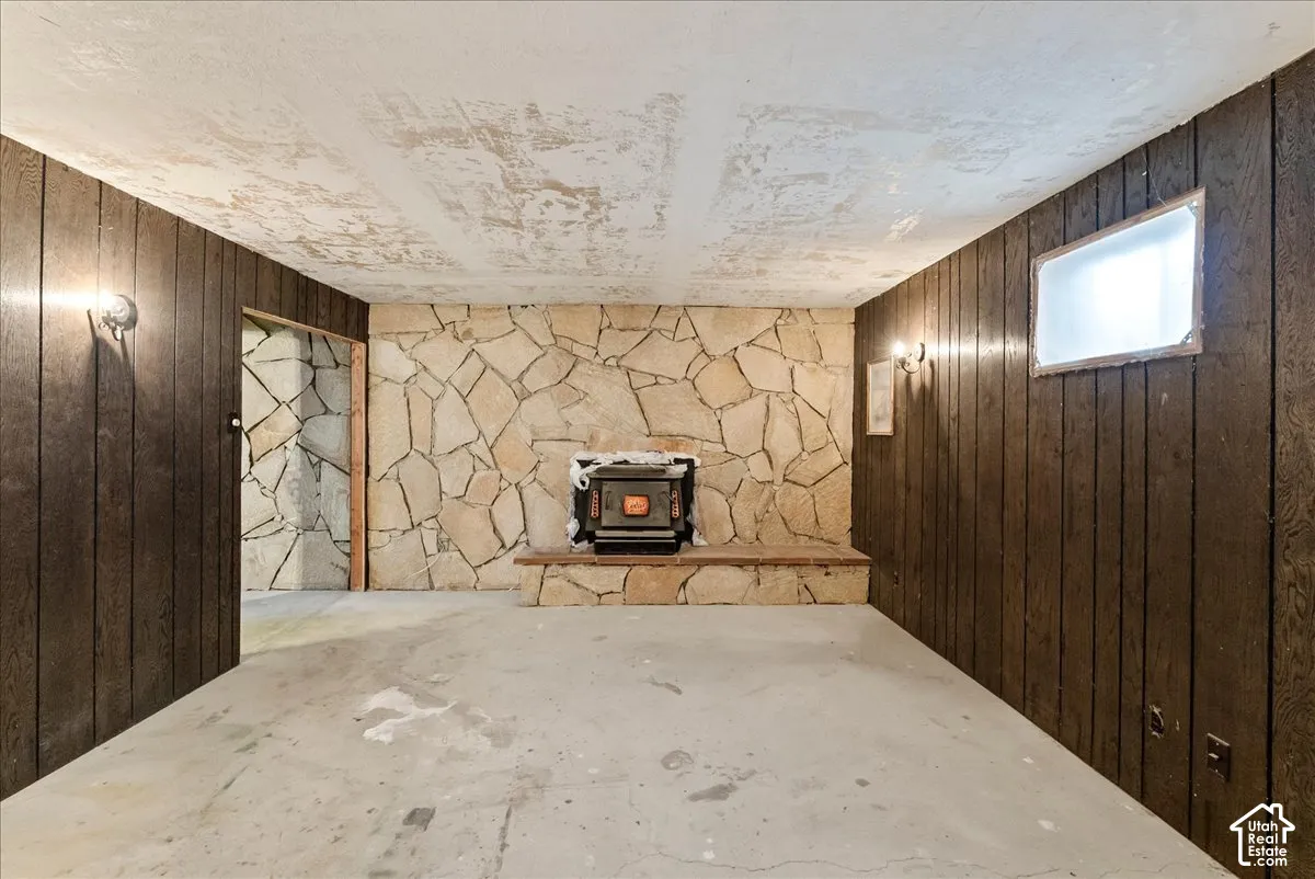 Room featuring a stone-clad fireplace with a wood-burning insert