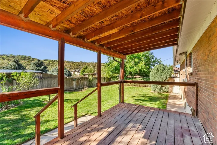 Covered wood-finish deck with wooden railing and support beams