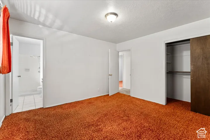 Recessed lighting fixture, white interior doors, sliding closet doors, built-in closet shelving, and textured white ceiling