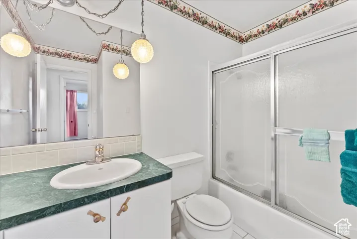 White vanity with a green countertop and integrated sink, chrome faucet, and a large wall-mounted mirror