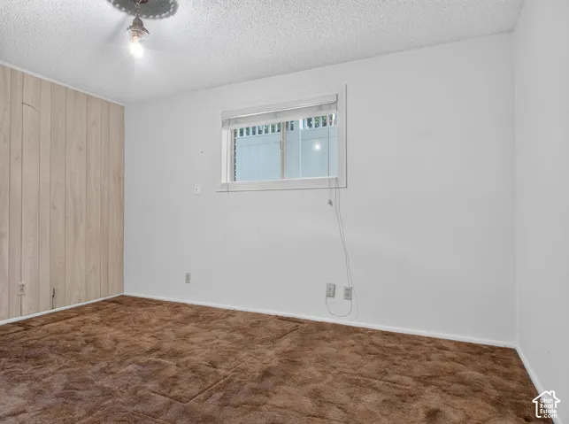 Wall paneling accent, ceiling-mounted light fixture, white interior walls, window with blinds