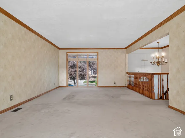 Spacious room with light-toned carpeting, wood-finish trim, and a full-light sliding glass door