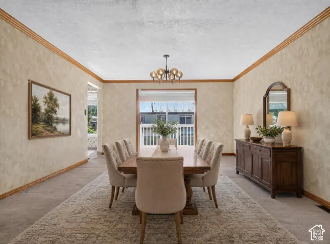 Recessed ceiling with an ornate chandelier, textured walls, and wood trim