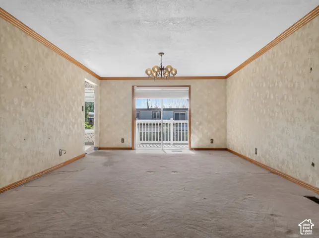 Recessed wall panels, overhead chandelier, and a sliding glass door with white railing