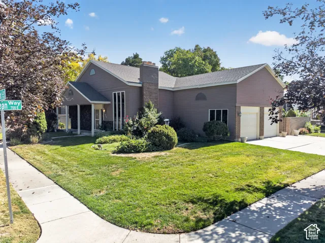 Corner lot with a two-car garage, mature landscaping, and a covered entry