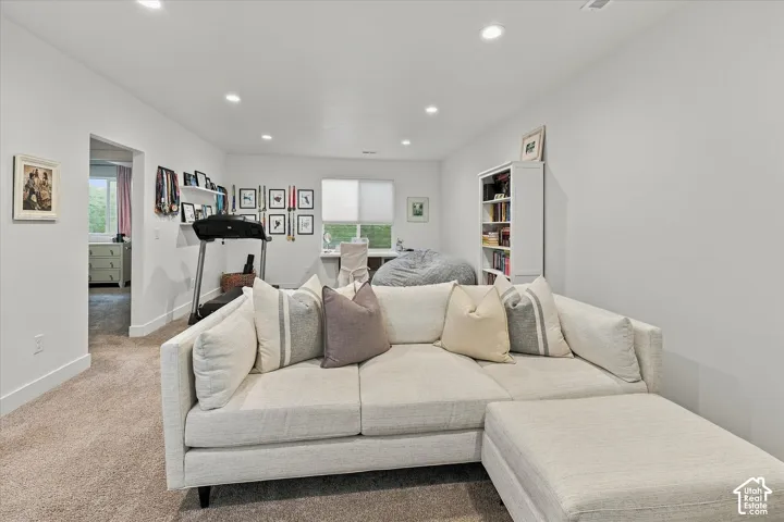 Recessed lighting illuminates the carpeted floor and white walls