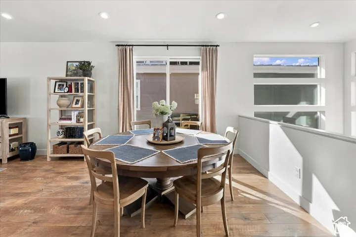 Wood-finish flooring throughout, recessed lighting, and a sliding glass door providing outdoor access